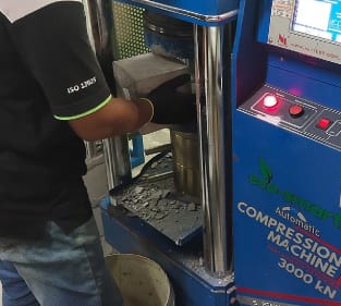 Operator using laboratory compression testing equipment